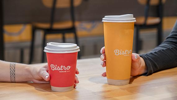 Hands holding Bistro coffee cups.