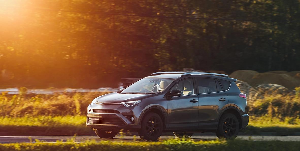 Grey car driving during a sunset.